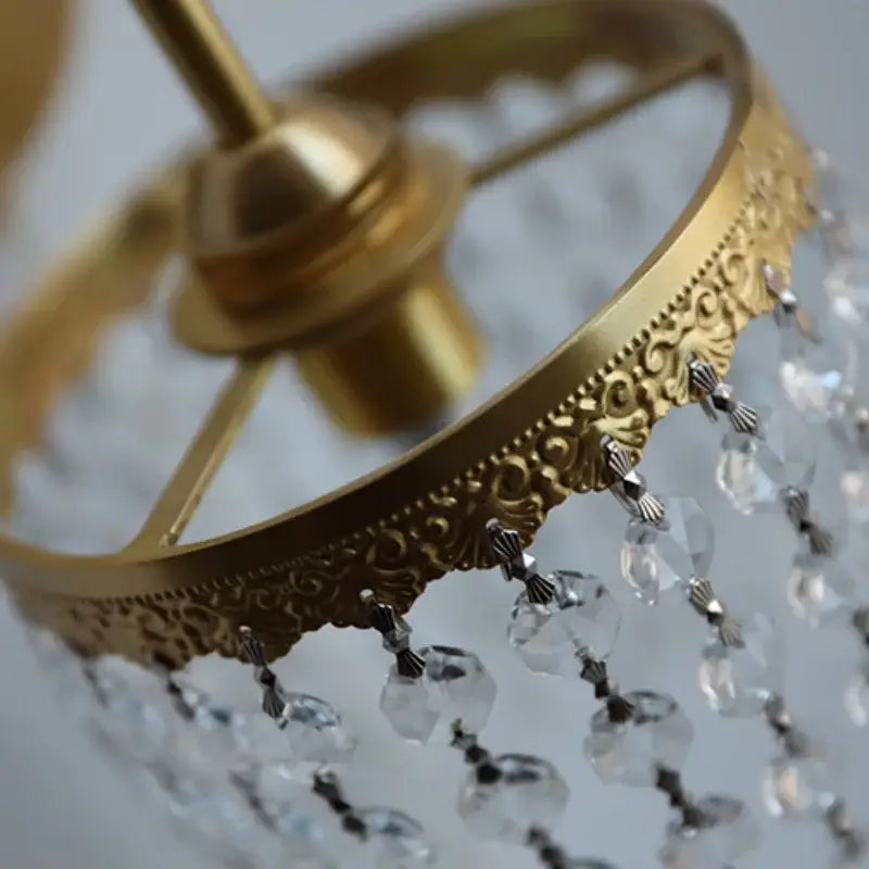 Antique brass crystal led wall sconce with gold-toned ornate scrollwork and dangling clear crystal beads decorbites crystal led