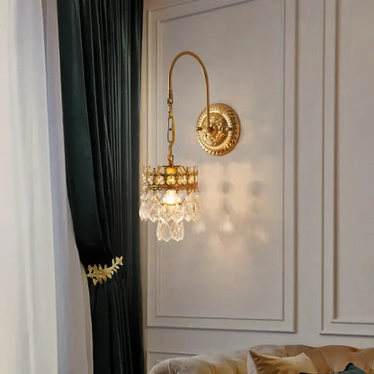 Antique brass crystal wall lamp with gold-toned curved arm and chandelier-style pendant for luxury bedroom decorbites crystal wall lamp