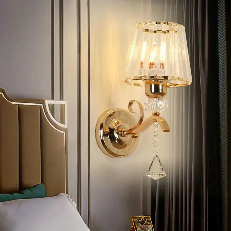 Gold-toned antique brass and dark bronze decorbites crystal led wall lamp with crystal lampshade and dangling crystals for living room