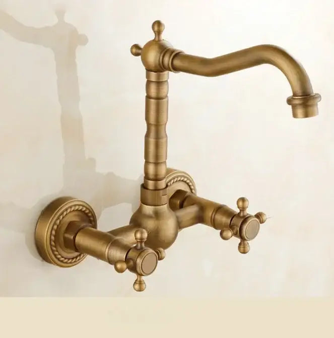 Antique brass dual handle kitchen faucet with porcelain plate, ornate cross handles and decorative rope detailing for hot water