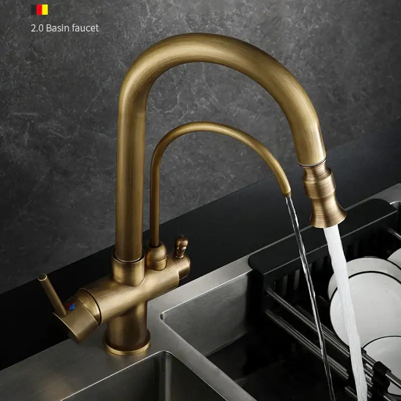 Antique brass dual handle kitchen faucet with curved spout and pull out spray head mounted over stainless steel sink