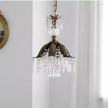 Antique brass leaf crystal pendant light featuring bronze finish, dangling crystal droplets, and a central glass orb chandelier