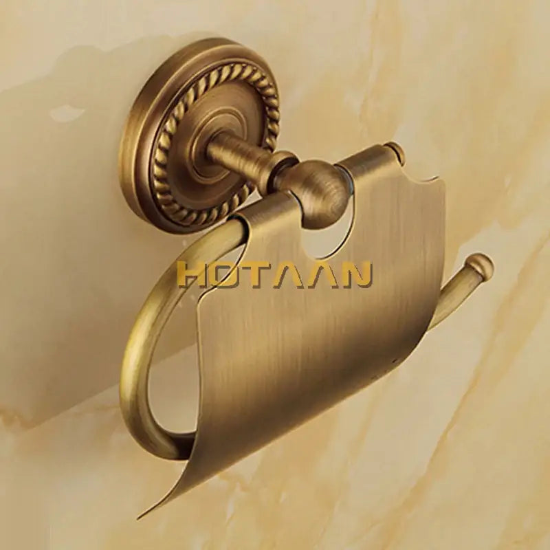 Antique brass rope twist toilet paper holder with ornate rope-textured base in brass bathroom set by decorbites