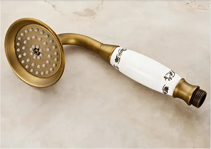 Antique brass round shower faucet set with white ceramic showerhead and black floral detailing for bathroom use