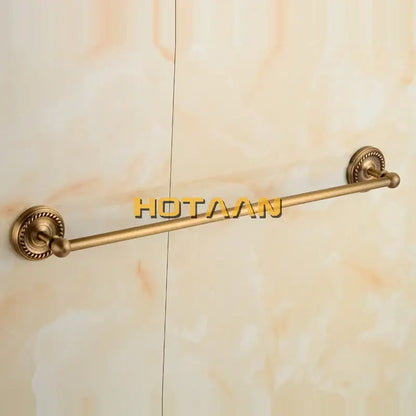 Antique brass single towel bar with ornate circular wall-mounted ends for classic bathroom decor