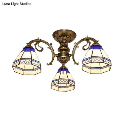 Antique brass-finished decorbites™ three-arm ceiling fixture with blue stained glass bell shades in geometric patterns