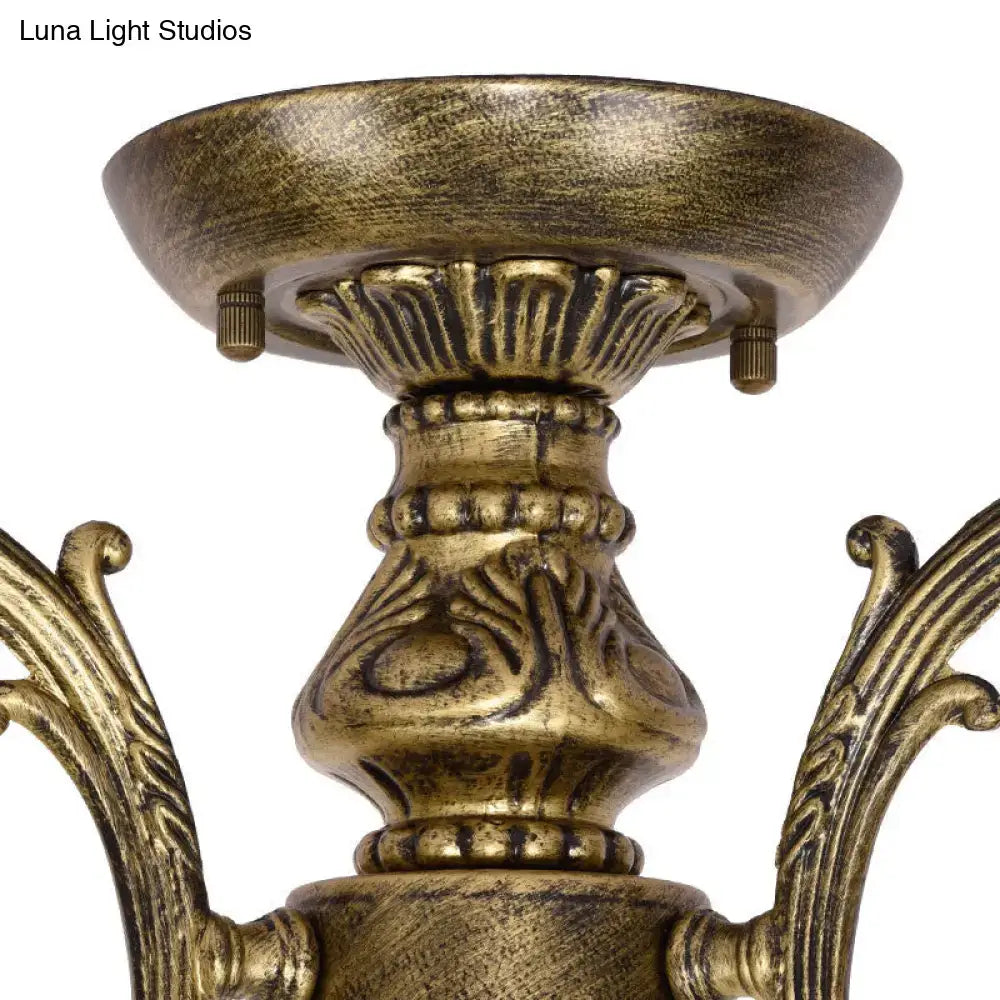 Antique brass-finished chandelier with ornate scrollwork and a blue stained glass bell shade semi flush mount fixture