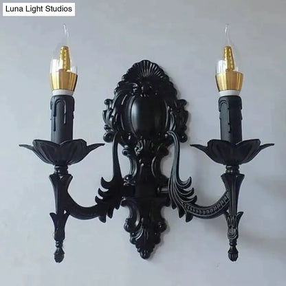 Black ornate wrought iron retro european wall sconce with two candle arms and gold finished bulb holders for bedroom lighting