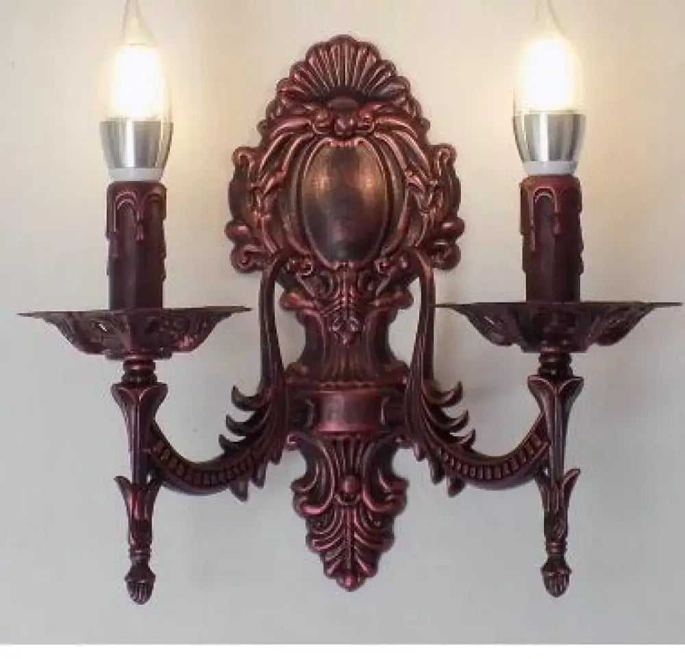 Antique gold retro European wall light ornate bronze-finished sconce with symmetrical design and two candle-like bulbs