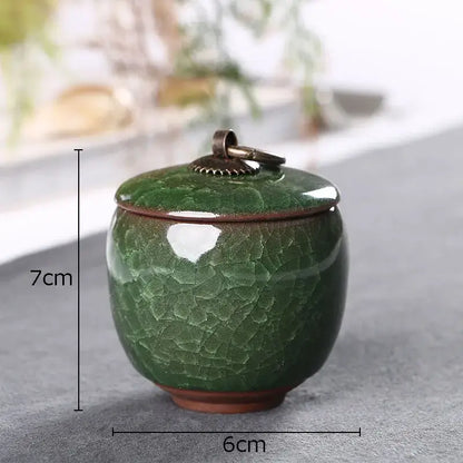 A small ceramic green tea caddy with ice cracked texture glaze and an antique bronze lid for kitchen storage