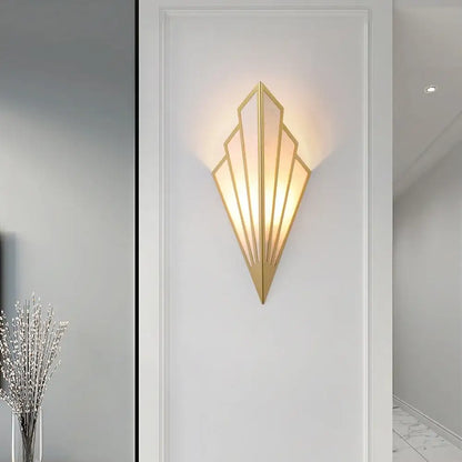Gold-toned art deco led wall lamp with geometric fan-shaped design and frosted glass panels for bedroom use