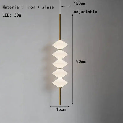 A modern art deco pendant light with five stacked white glass diamond-shaped shades on a brass iron rod