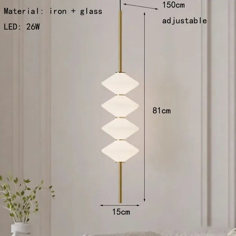 Art deco pendant light with a slender brass iron rod and three stacked softly glowing white glass discs for dining room