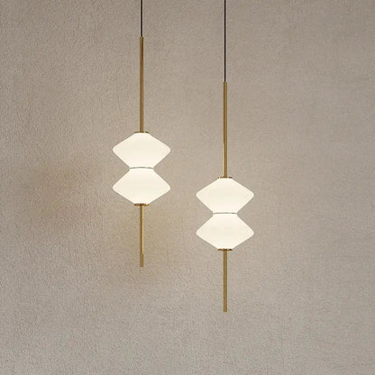 Two elegant art deco pendant lights with gold-toned rods and stacked white glass shades for dining room lighting
