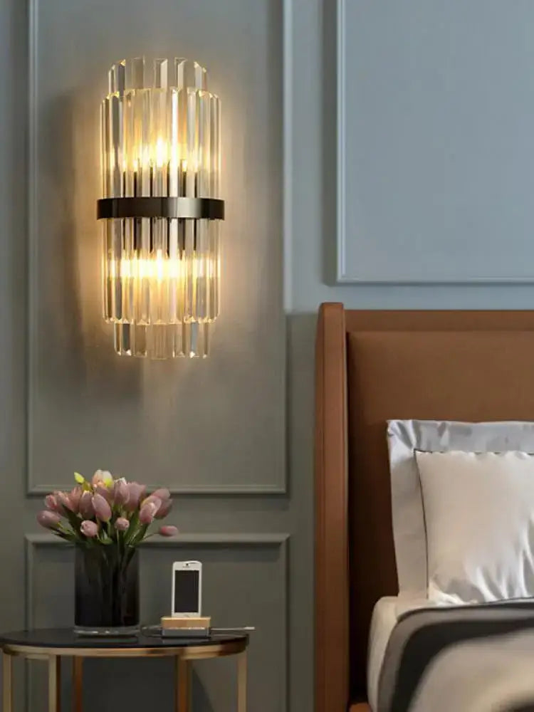 Art deco black gold stainless wall sconce with vertical crystal rods and sleek black metal band illuminating bedroom decorbites art deco
