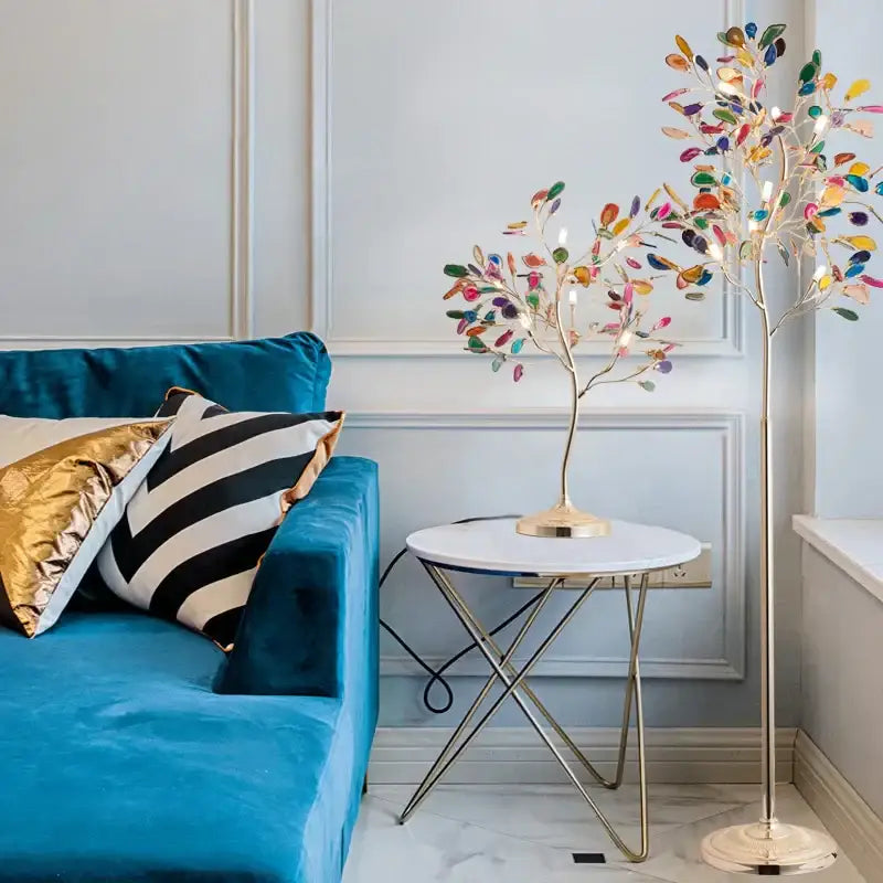 A tall slender decorbites agate floor lamp with gold metal base and colorful translucent leaf lights for living room decor