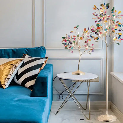 A tall slender decorbites agate floor lamp with gold metal base and colorful translucent leaf lights for living room decor