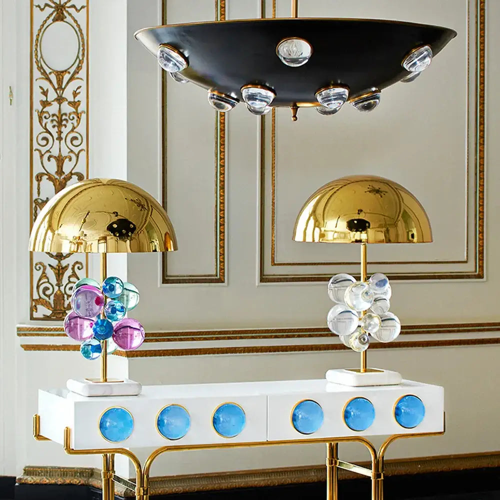 Two art deco gold and crystal bubble led bubble led desk lamps with vibrant glass orbs on white marble base console