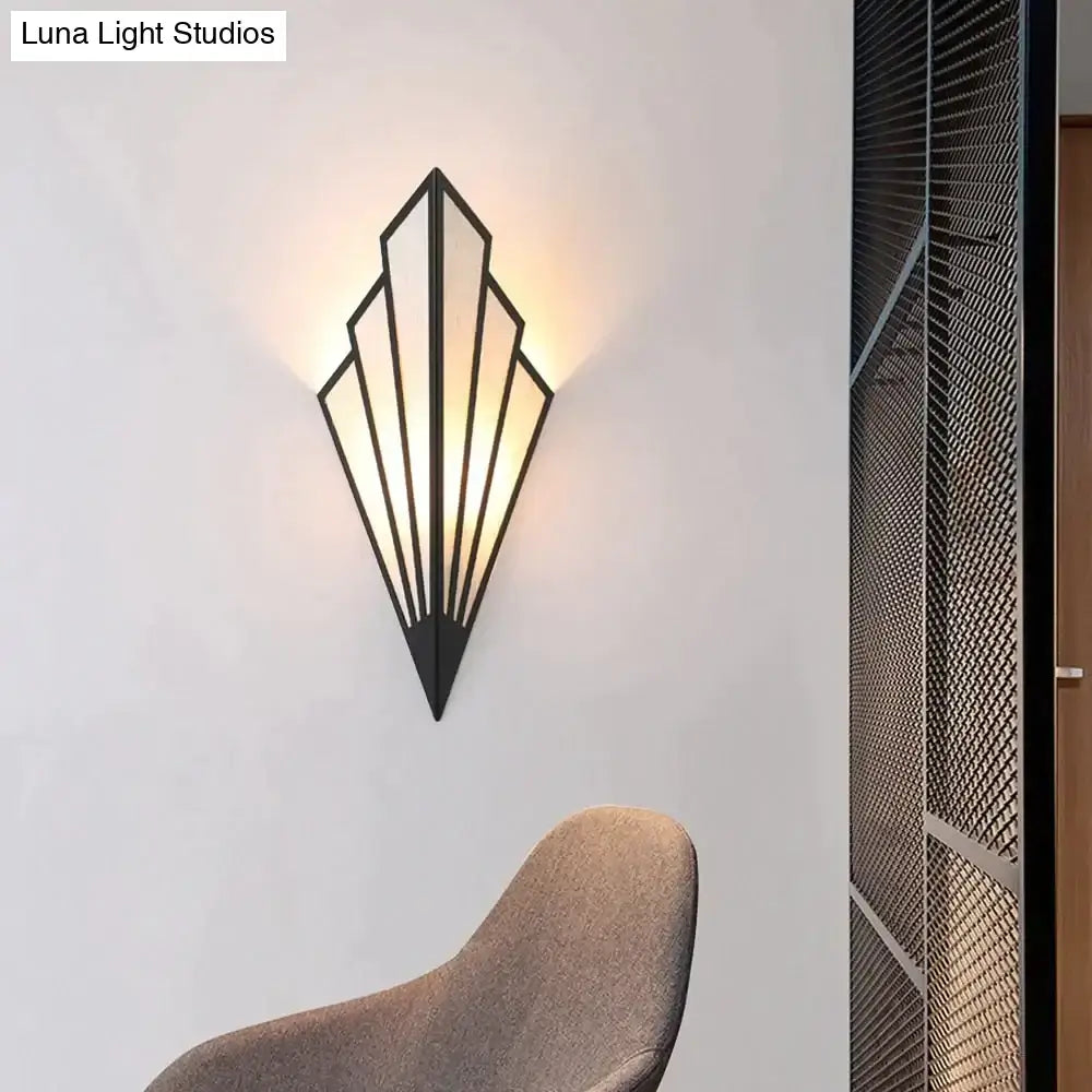 Black metal art deco wall light with geometric fan shape modern design and warm ambient lighting for bedroom