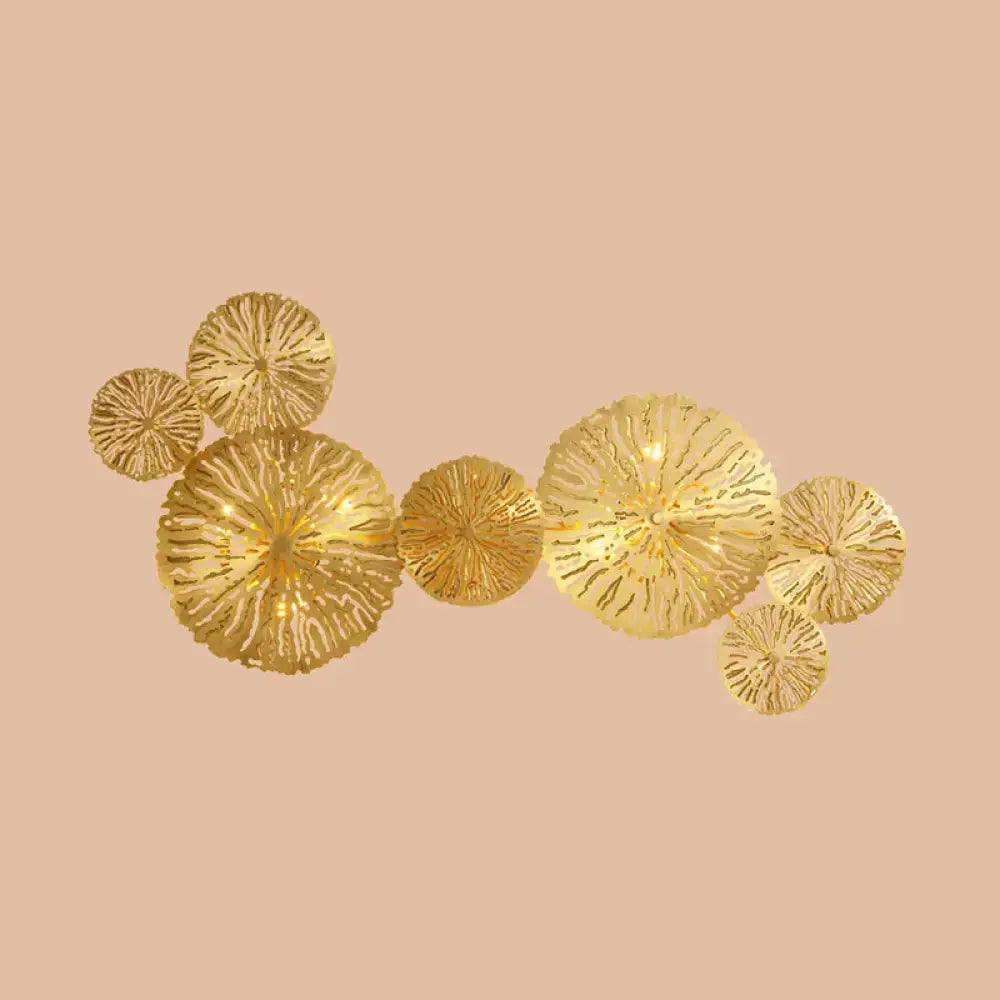 Gold-colored metal art deco wall mount light fixture featuring intricate coral-inspired circular design for bedroom sconce