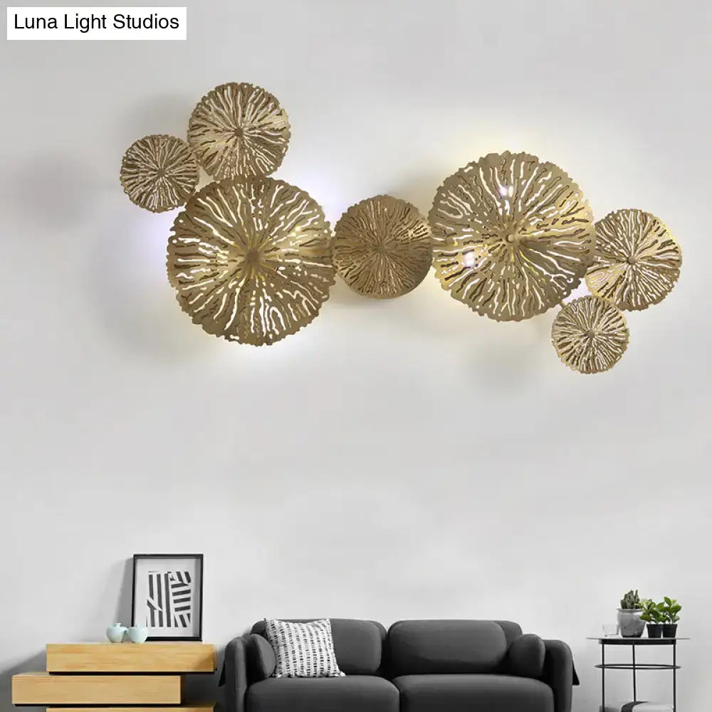 Gold-toned metal art deco wall mount light fixture with intricate circular leaf shapes for bedroom sconce decor