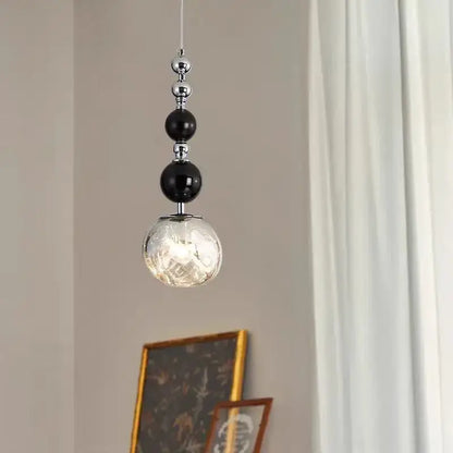 Art deco pendant light with black and chrome beads and textured glass globe for living room square meters lighting