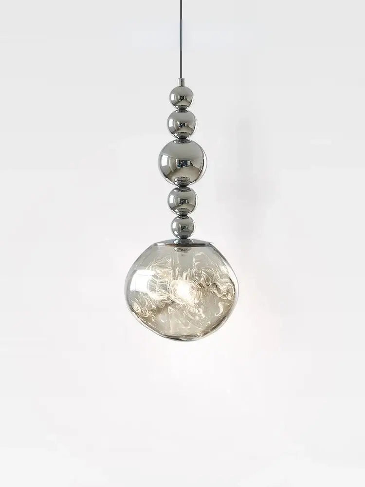 A modern art deco silver pendant light with polished chrome spheres and a textured glass globe for living room