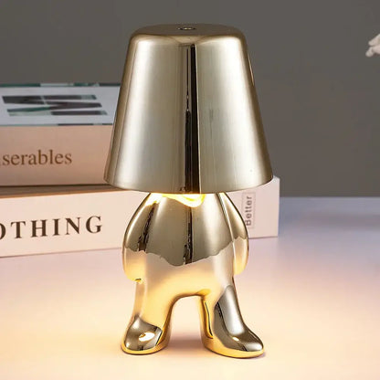 Articulated golden man table lamp made of shiny metallic gold designed as night light for bedroom use