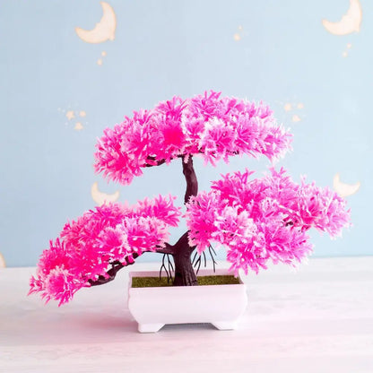 Vibrant pink artificial bonsai tree with feathery foliage and dark brown trunk in white ceramic pot for decor