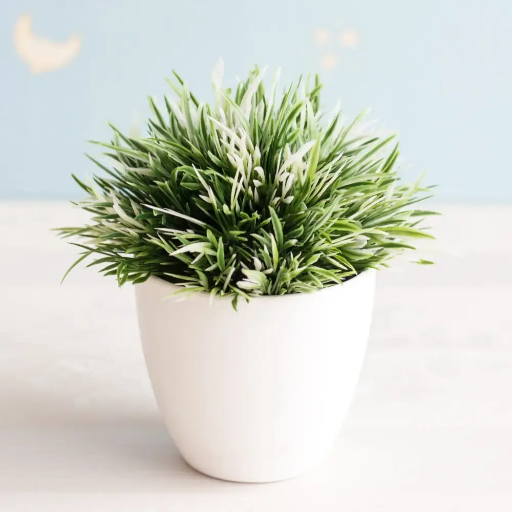 White ceramic pot holding an artificial bonsai tree with dense spiky variegated green and white leaves garden decor