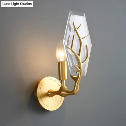 Artistic gold-toned antler wall lamp with faceted crystal backplate for elegant living room light fixture