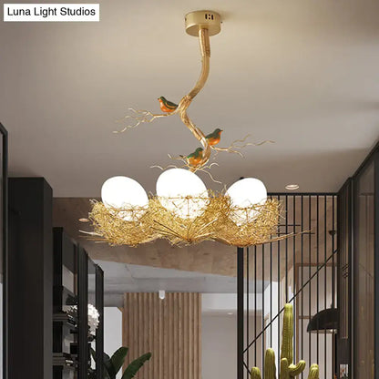 Golden bird-themed chandelier with milk white glass ball bulbs nestled in a hand-sewn aluminum nest pendant lamp