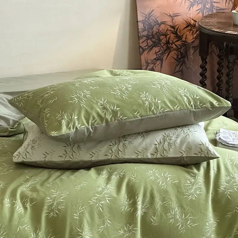 A soft sage green cotton pillow sham with white bamboo leaf jacquard pattern and satin piping in bedding set decorbites bamboo leaf