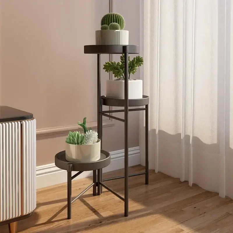 Dark gray metal three-tier plant stand with circular shelves holding green cacti as an alternative to decorbites bamboo plant stand