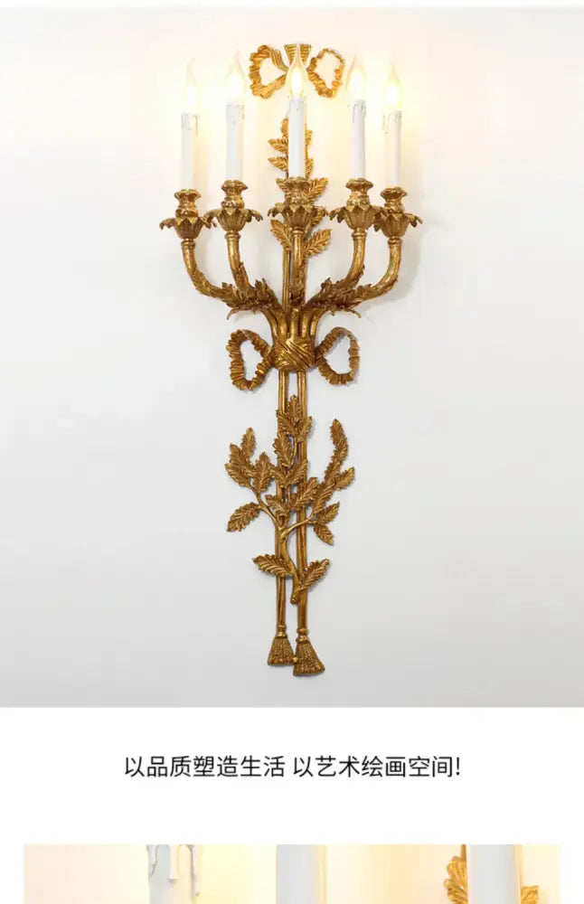 Golden baroque antique brass wall sconce with five candle lights and ornate leaf and ribbon decor by decorbites