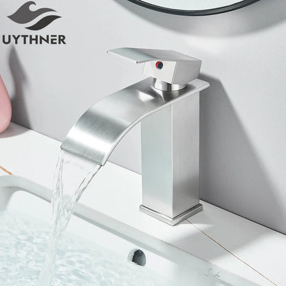 Modern brushed stainless steel bathroom sink faucet with waterfall design and red indicator dot on handle deck mount