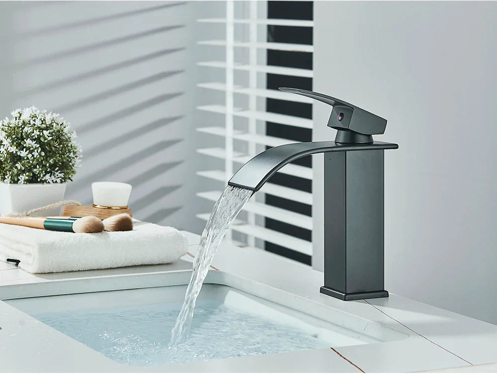 Modern matte black brass bathroom sink faucet with stainless steel waterfall-style spout deck mount design
