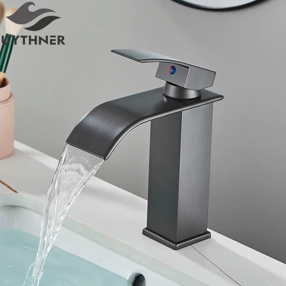 Matte black brass bathroom sink faucet with stainless steel waterfall spout and blue-red temperature indicator handle