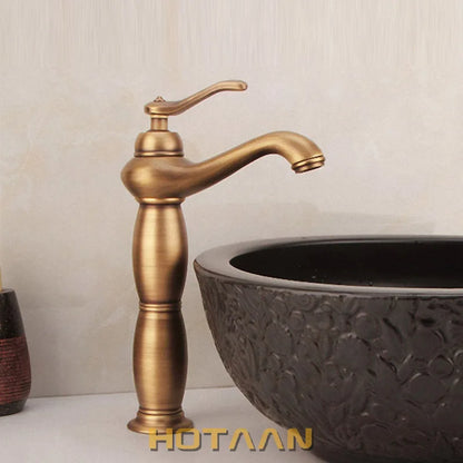 Antique brass-finished tall basin bathroom faucet with single handle curved spout and ornate cylindrical base