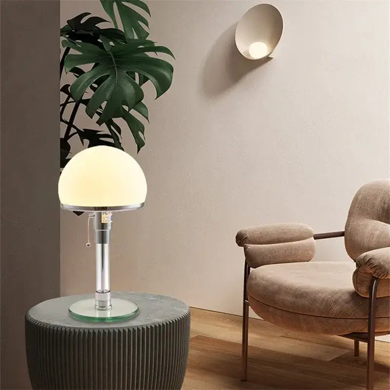 Bauhaus chrome table lamp with a milk white glass spherical shade and polished stem for bedroom lighting