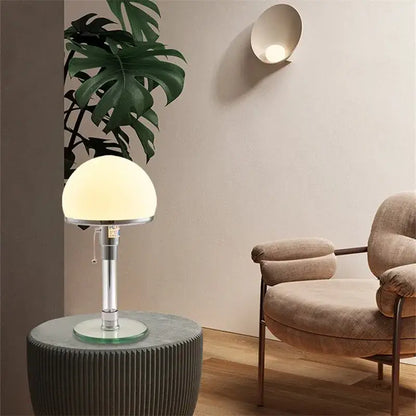 Bauhaus chrome table lamp with a milk white glass spherical shade and polished stem for bedroom lighting