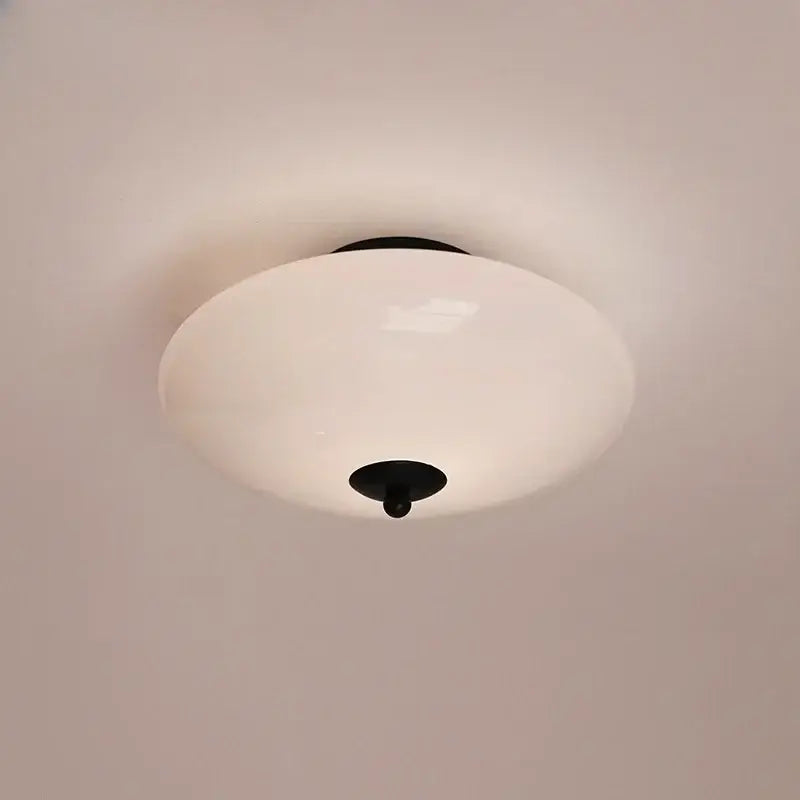A sleek bauhaus ceiling lamp with cream white glass shade and black metal accents for dining room decorbites cream white