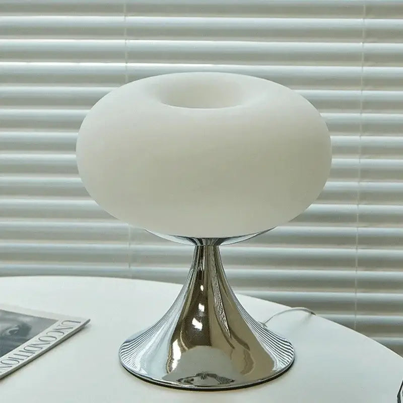 A sleek led table lamp with a frosted white glass dome and polished chrome base for living room use