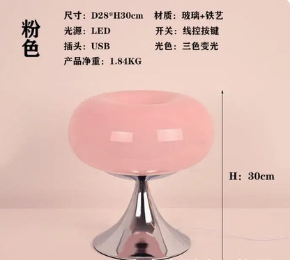 A sleek translucent pink glass led table lamp with polished chrome base and stem for living room use