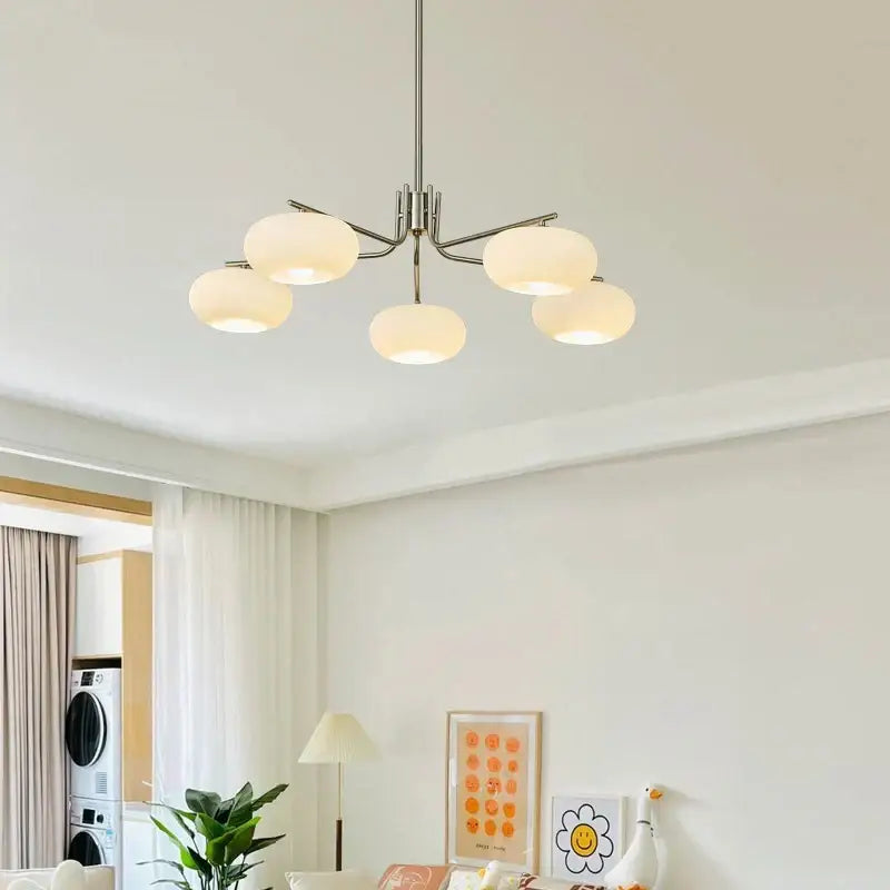 Modern five-light persimmon chandelier with milk white glass globes and sleek metallic finish for dining room lighting