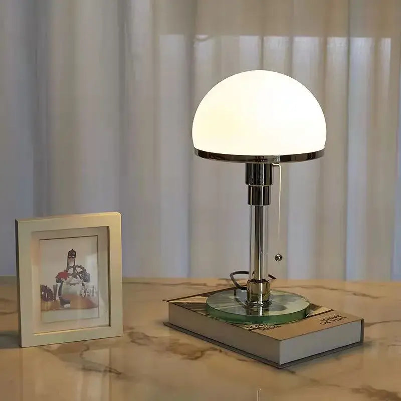 Bauhaus mushroom table lamp with chrome finish, white glass dome shade, and circular glass base for bedroom use