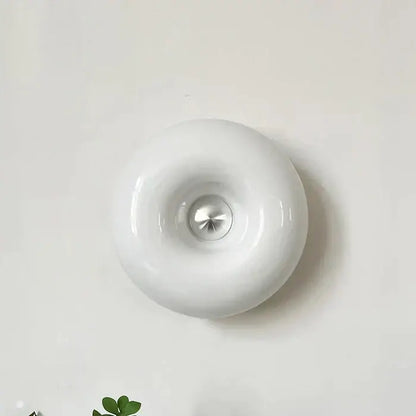 White ceramic wall lamp with glossy finish and central metallic accent decorbites donut wall lamp for bedroom light