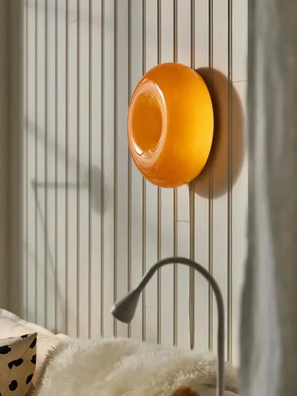 Vibrant orange glossy circular decorbites donut wall lamp with smooth modern design for bedroom atmosphere light