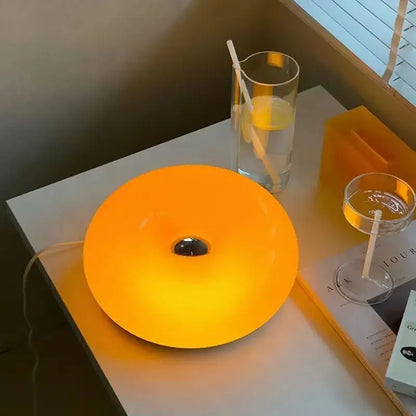 Bauhaus orange glass style soap dish with a glowing orange glass table lamp featuring a central dark hole