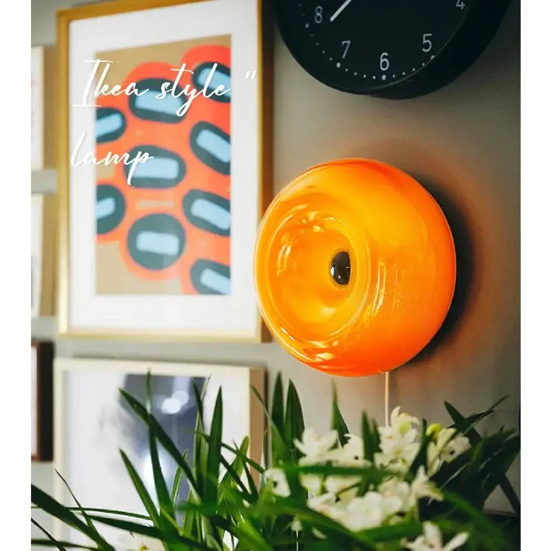 Vibrant bauhaus orange glass wall lamp with a glossy circular design perfect for modern bedroom accessories